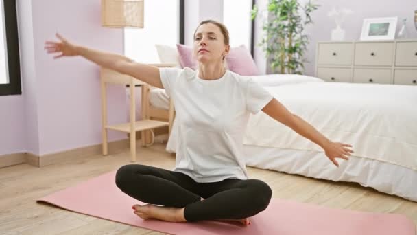 一个年轻的高加索女人躺在一个整洁整洁的卧室里的瑜伽垫上 有着洁白和紫色的色调 散发着平静和宁静的气息 — 图库视频影像