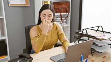 Ofis yerinde elma yiyen İspanyol kadın, sağlıklı ve sıradan görünüyor..