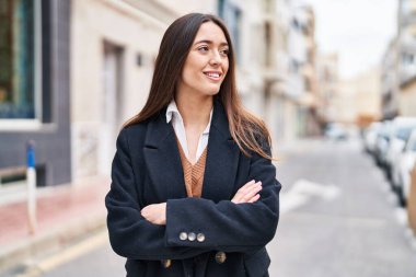 Sokakta kollarını kavuşturmuş genç, güzel İspanyol bir kadın.