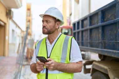 Sokaklarda akıllı telefon kullanan orta yaşlı bir mimar.