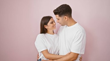 Sevgi dolu bir çift pembe bir arka plana sarılıyor. Sevgi ve birlikteliği resmediyor.