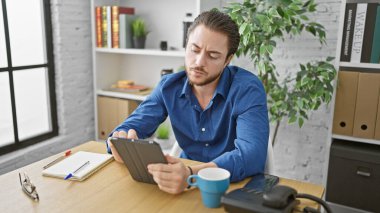 Genç İspanyol iş adamı ofiste dokunmatik düşünmeyi kullanıyor.