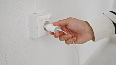 İspanyol adamın elleri evdeki enerjiyi şarj ediyor. Teknolojisini elektrik prizi ile çalıştırıyor.