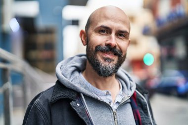 Genç kel adam gülümsüyor. Kendine güveniyor.