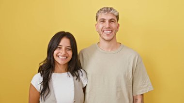 Mutlu erkek ve kadın kucaklaşır, sevgi ve şefkat gösterir, parlak sarı izole bir arka plana karşı.