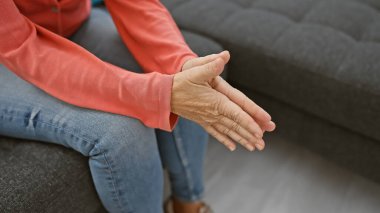 Ev ortamında el ağrısı gösteren tanınmayan orta yaşlı bir kadının yakın çekimi..