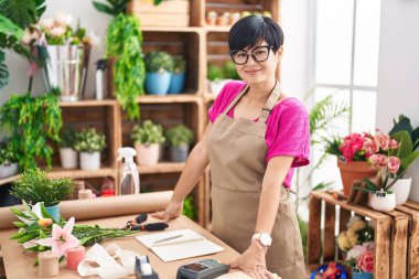 Middle age chinese woman florist smiling confident standing at flower shop