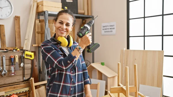 Una Mujer Sonriente Con Orejeras Protectoras Sosteniendo Taladro Taller Carpintería —  Fotos de Stock