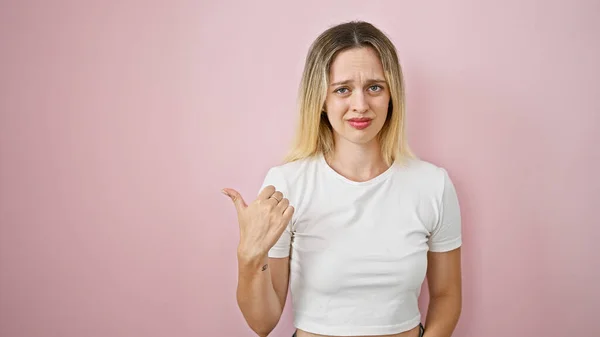 Mladá Blondýnka Žena Ukazuje Stranu Prstem Vypadající Rozrušený Přes Izolované — Stock fotografie