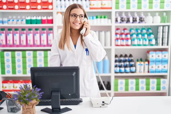 Young Beautiful Hispanic Woman Pharmacist Talking Telephone Using Computer Pharmacy — Stockfoto