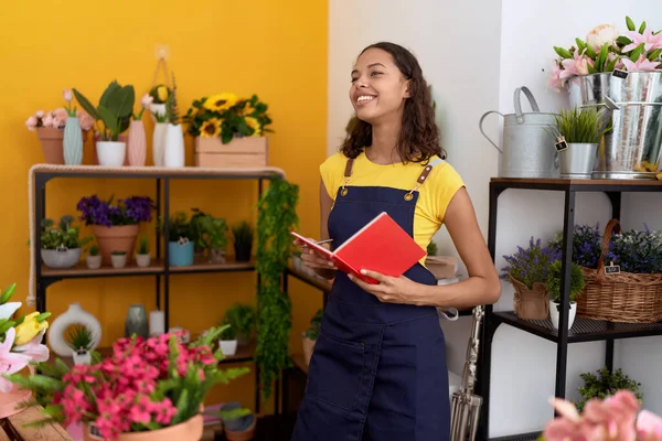 Genç Afro-Amerikan kadın çiçekçi. Çiçekçide kendine güvenen, not defterine yazan.