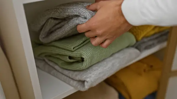 男性はワードローブでセーターを組織し 衣料品の保管ソリューションに焦点を当てた家庭内インテリアの整頓を示しています — ストック写真