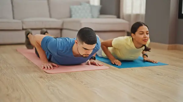 Beautiful couple showcasing power and love, training together with indoor push up workout at home