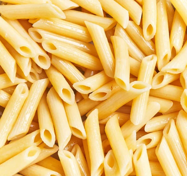 Close View Uncooked Penne Pasta Fills Frame Illustrating Texture Abundance — Stock Photo, Image