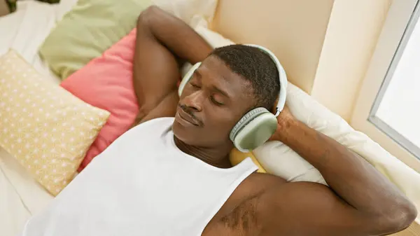 Hombre Afroamericano Relajado Disfrutando Música Con Auriculares Ambiente Cómodo Casa —  Fotos de Stock