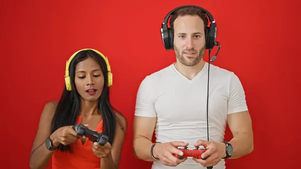 Schönes Paar Lächelt Zuversichtlich Videospiel Über Isolierten Roten Hintergrund — Stockfoto
