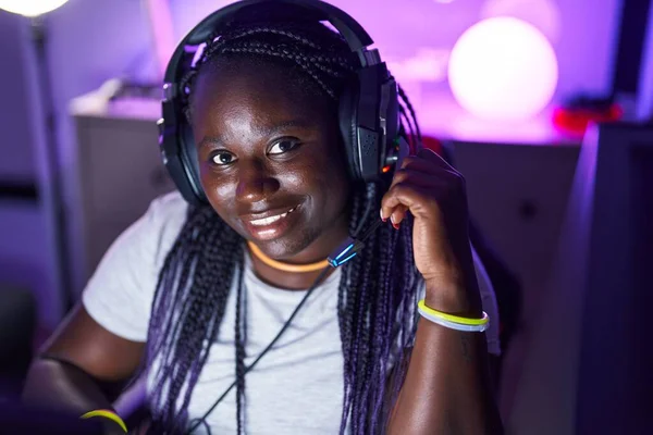 African american woman streamer smiling confident sitting on table at gaming room