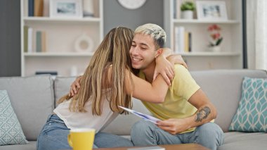 Evdeki kanepede oturmuş belge okuyan güzel bir çift.