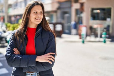 Sokakta kollarını kavuşturmuş genç, güzel İspanyol bir kadın.