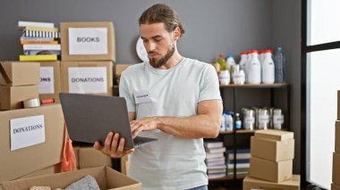 Yardım merkezinde dizüstü bilgisayar kullanan genç bir İspanyol gönüllü.