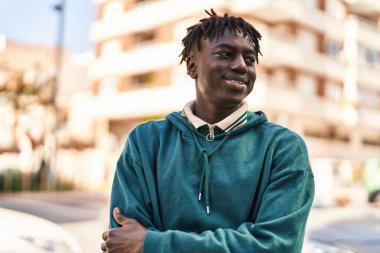 Sokakta eli kolu çapraz hareket eden Afrikalı Amerikalı bir adam.