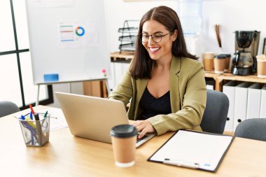 Young beautiful hispanic woman business worker using laptop working at office