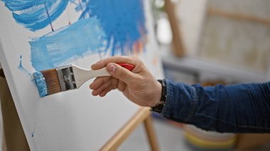 Yakışıklı İspanyol bir adam, hevesli bir sanatçı, yaratıcılıkla dolu bir sanat stüdyosundaki fırçayla tutkuyla tuvale resim çiziyor.