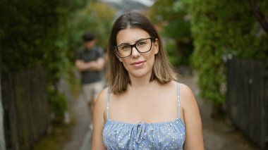 Kendine güveni tam İspanyol bir kadın, spor gözlükleri ve ciddi bir ifadeyle, onu Kyoto 'nun geleneksel sokaklarında ayakta tutuyor.