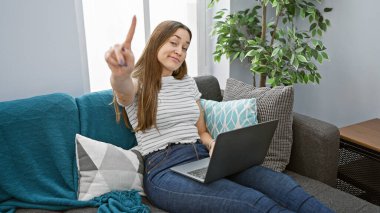Genç bir kadın, rahat bir oturma odasında dizüstü bilgisayarla hayır diyor..
