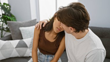 Samimi bir kadın, sıcak, modern bir oturma odasında erkeğe yaslanıyor. Aşkı ve birlikteliği simgeliyor..