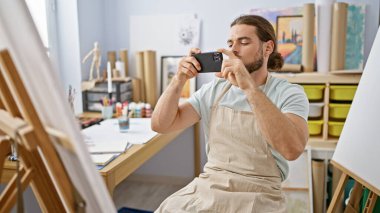 Genç İspanyol ressam resim çizmek için resim çekiyor.