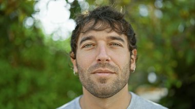 Sarışın sakallı, yakışıklı İspanyol genç adam, şehir parkında yakalandı; onun rahatlamış ama ciddi ifade derin, konsantre düşünceleri ipucu