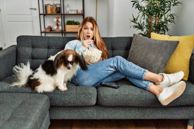 Beyaz bir kadın evde köpekle birlikte kanepede oturup film izlerken şaşırdı.