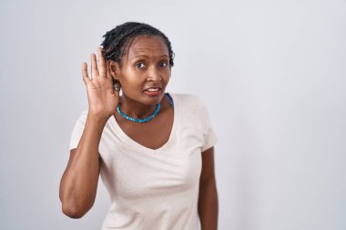 Beyaz arka planda oturan Afrikalı kadın. Kulağı kulağında gülümsüyor. Dedikoduları ve dedikoduları dinliyor. Sağırlık kavramı. 
