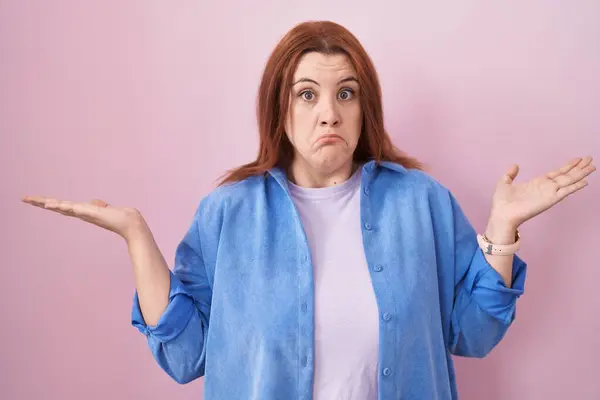Young Hispanic Woman Red Hair Standing Pink Background Clueless Confused — Stock Photo, Image