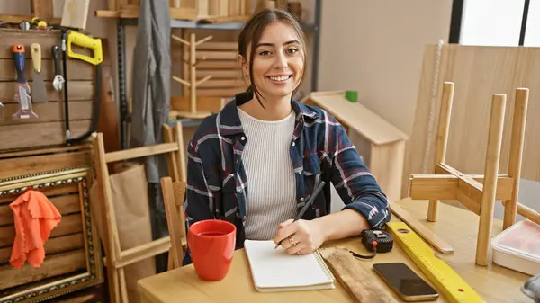 Glimlachende Spaanse Vrouw Maakt Plannen Een Goed Georganiseerde Timmerwerkplaats — Stockfoto