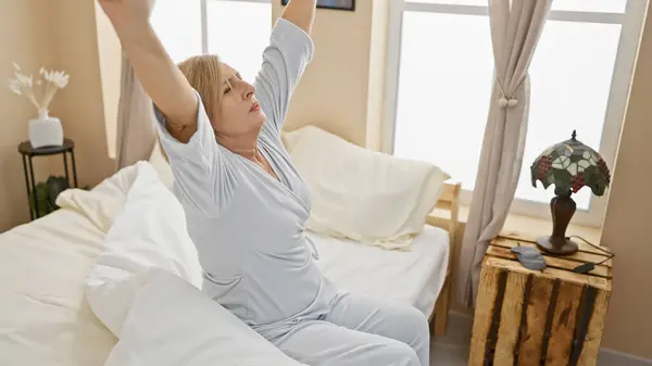 Middle-aged woman stretches morning bedroom