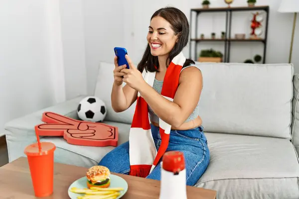 Genç Güzel Spanyol Bir Kadın Evde Akıllı Telefon Kullanarak Futbol — Stok fotoğraf