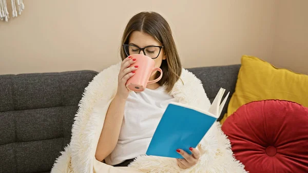 Young Hispanic Woman Enjoys Reading Sipping Tea Relaxing Sofa Cozy — Stock Photo, Image