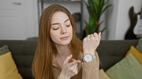 Młoda Kobieta Sprawdza Czas Zegarku Przytulnym Salonie — Zdjęcie stockowe