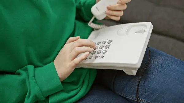 Young Woman Dials Landline Phone While Sitting Couch Capturing Casual — Stock Photo, Image
