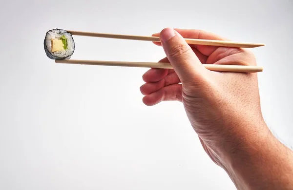 Man Hand Skillfully Holds Sushi Chopsticks White Background Capturing Culinary — Stock Photo, Image