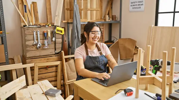 Smiling Hispanic Woman Works Laptop Woodwork Workshop Surrounded Tools Lumber — Stock Photo, Image