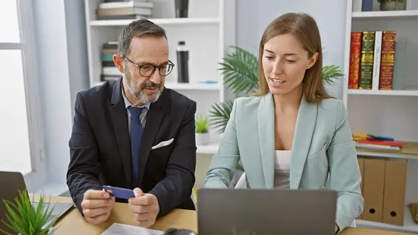 两个自信的商业伙伴在办公室使用笔记本电脑和信用卡时 一起笑着 享受着成功的网上购物狂潮 — 图库照片