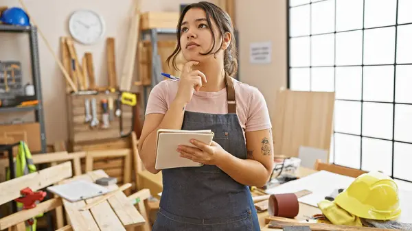 Thoughtful Hispanic Woman Tablet Pondering Carpentry Workshop Surrounded Wood Tools — Stock Photo, Image
