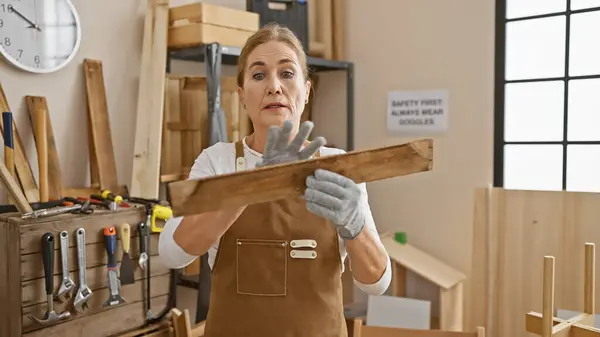 Mature Woman Examines Wood Quality Carpentry Workshop Surrounded Tools Workbench — Stock Photo, Image