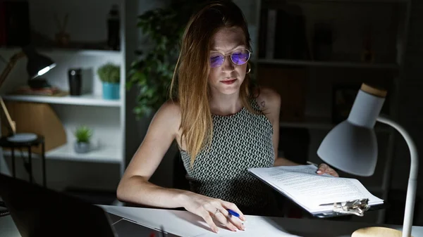 Young blonde woman business worker reading document working at the office
