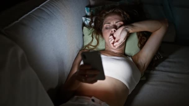 Молода Жінка Лежить Дивані Вдома Втомившись Використовувати Смартфон Вночі Представляючи — стокове відео