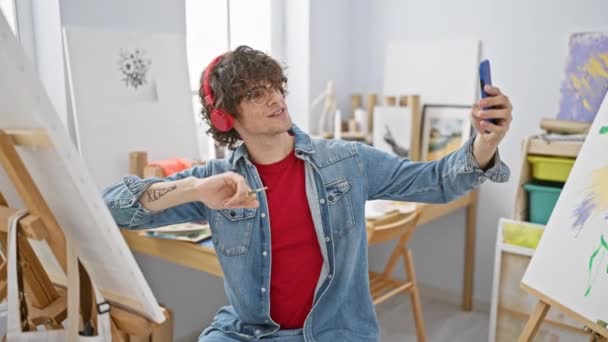 Cheerful Man Denim Jacket Takes Selfie Phone Art Studio — Stock Video