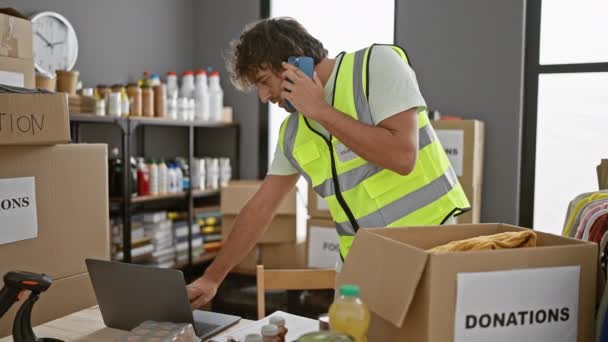 Man High Visibility Vest Multitasking Phone Laptop Boxes Labeled Donation — Stock Video